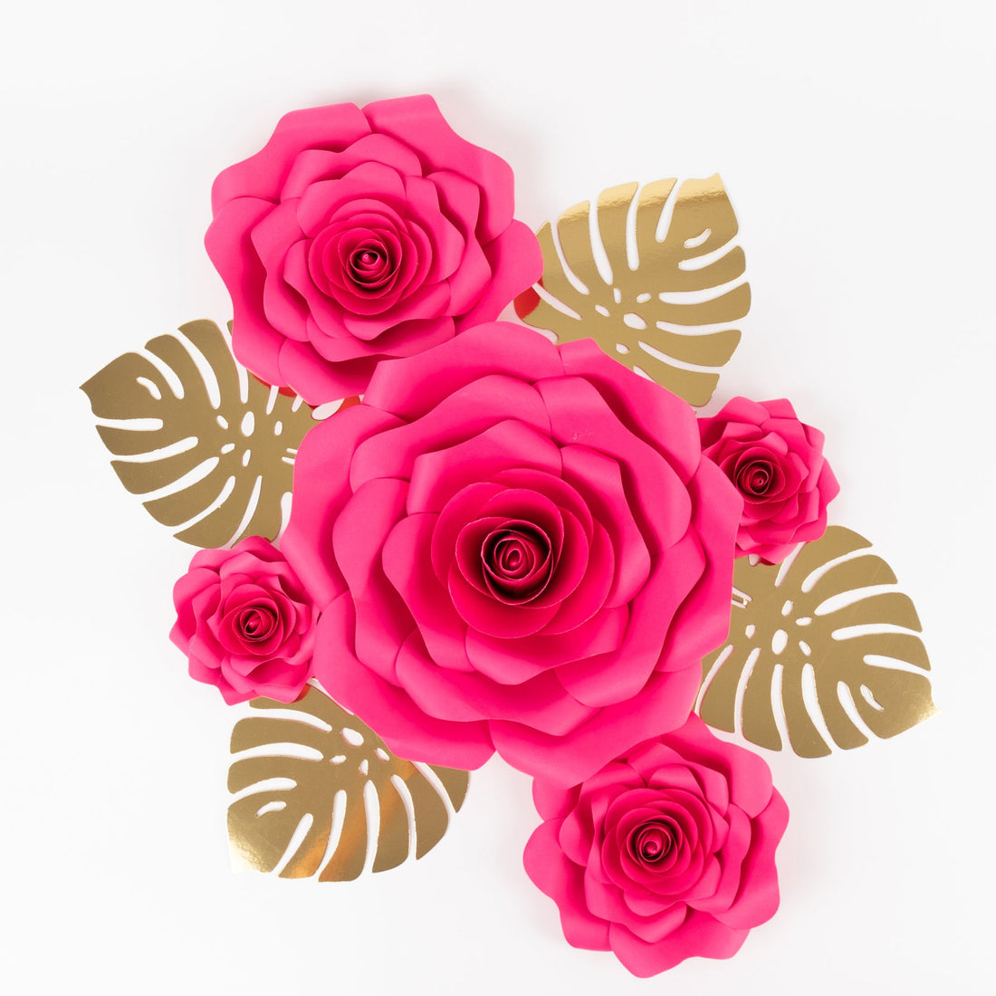 Pink paper roses with gold leaves on a white background.