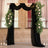 Elegant wedding arch with black drapes and white roses surrounded by greenery.