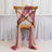 Elegant chair with soft, flowing fabric drapes in pink and burgundy tones.