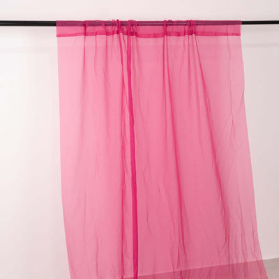 Pink sheer curtain panel hanging on a rod.