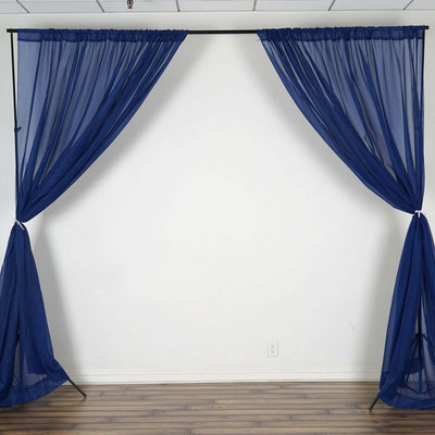 Navy blue sheer curtains draped on a backdrop stand