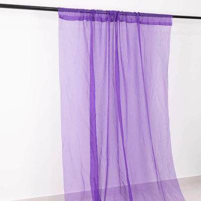 Purple sheer curtain draped on a rod against a white backdrop