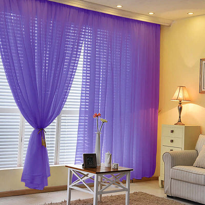Purple sheer curtains in a bright living room with furniture and decor.