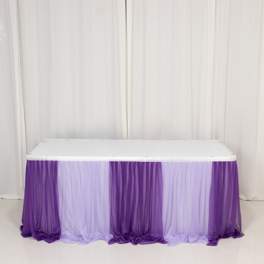 White table with purple and lavender draped tablecloth