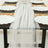 Elegant white table runner with pearl accents on a styled dining table.