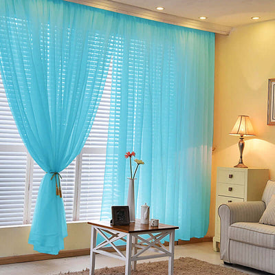 Light blue sheer curtains draping a sunny living room with a cozy sofa.