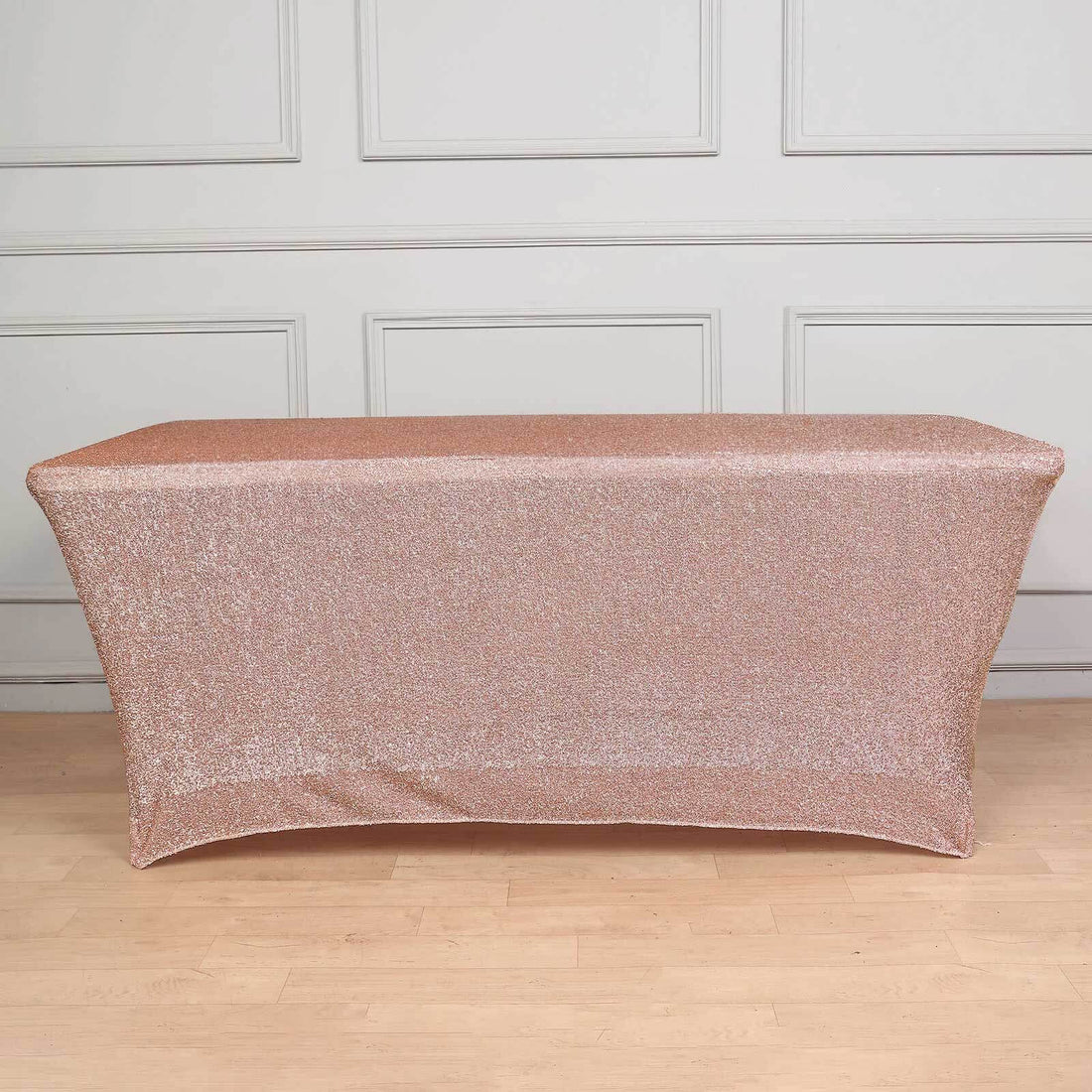 Rose gold sequin table cover on a plain backdrop.