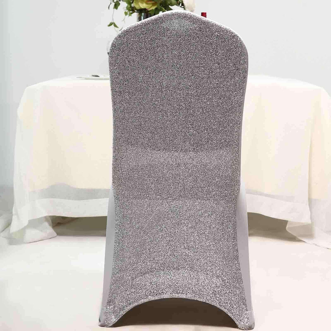 Sparkling silver dining chair on a white table setting.