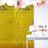 Party setup with gold backdrop, cake, and cupcakes on a white table.