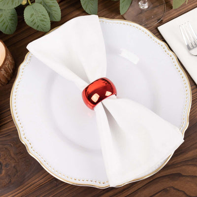 Elegant white dinner plate with a folded napkin and red napkin ring.
