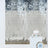 Mirrored wall backdrop with a white cake on a pedestal.