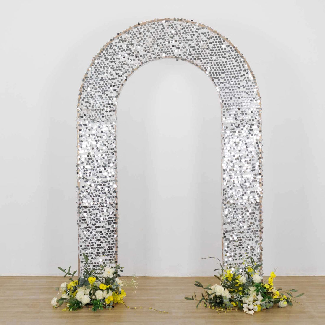 Decorative silver arch with floral arrangements at the base.