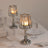 Elegant crystal candle holders with soft glowing candles on a dinner table setting.