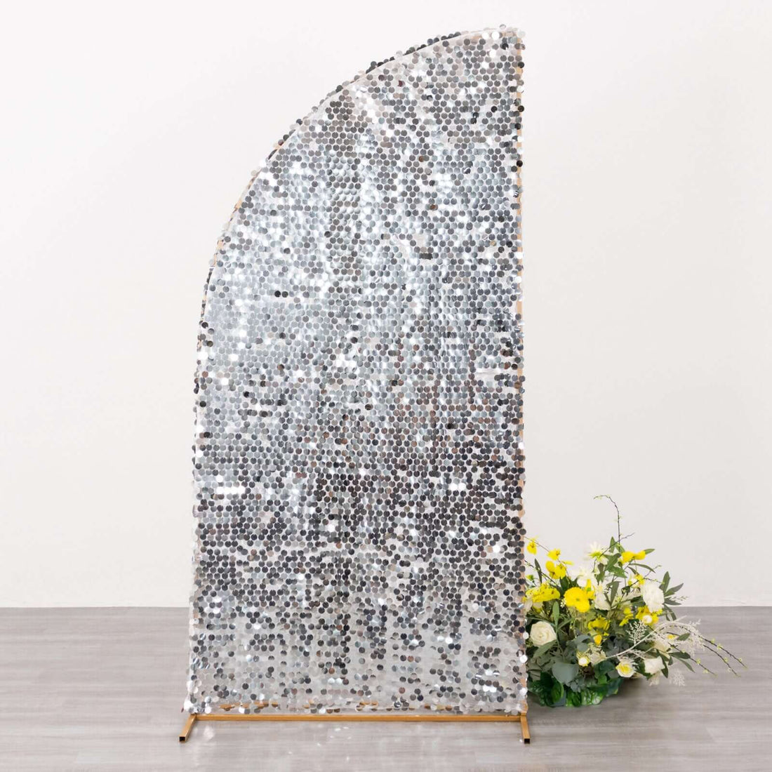 Decorative sequined backdrop with floral arrangement at the base.