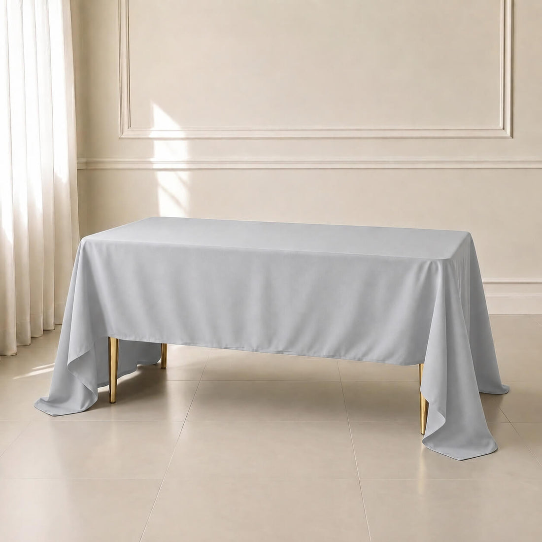Silver polyester rectangle tablecloth on a table in a bright room.