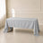 Silver polyester rectangle tablecloth on a table in a bright room.