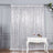 Silver sequin curtain draped elegantly behind a white decorative table.