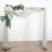 Elegant wedding arch draped with soft fabric and floral accents.
