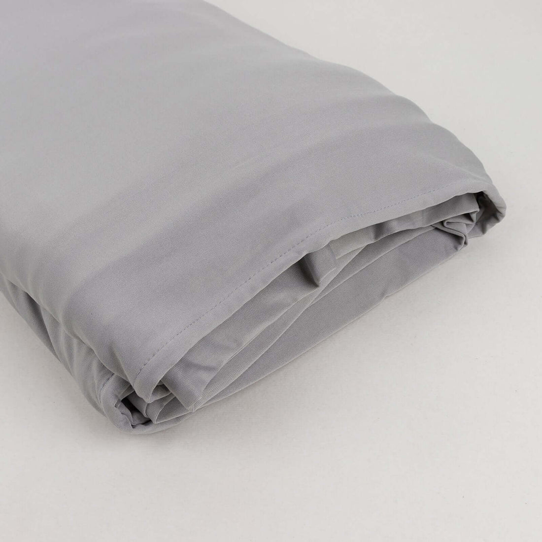 Gray folded comforter on a plain background.