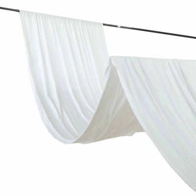 White fabric draped on a rod, creating soft folds and waves.