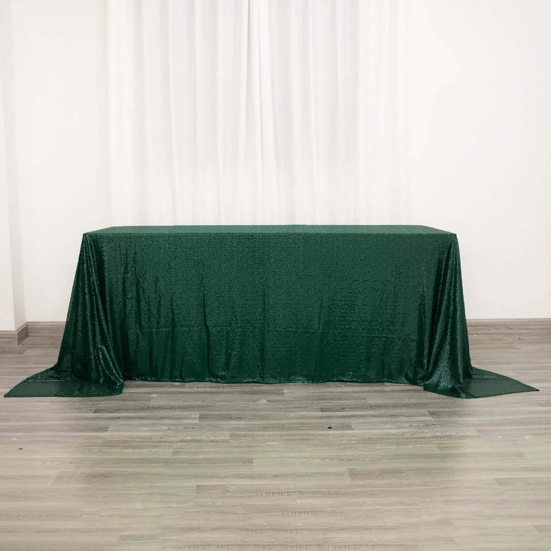 Green sequin tablecloth draped over a table for events and decorations.