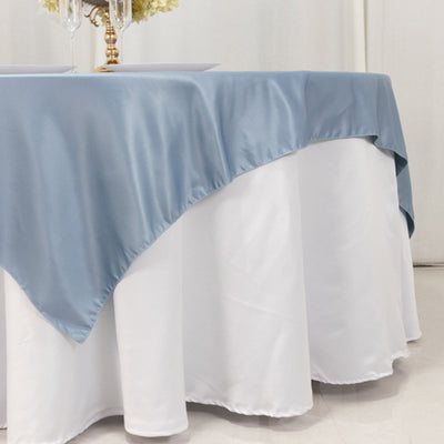 Blue satin tablecloth draping over a white table for elegant decor.