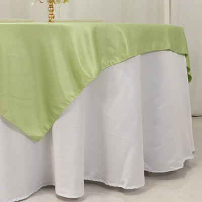 Green tablecloth draped over a white table for elegant dining.