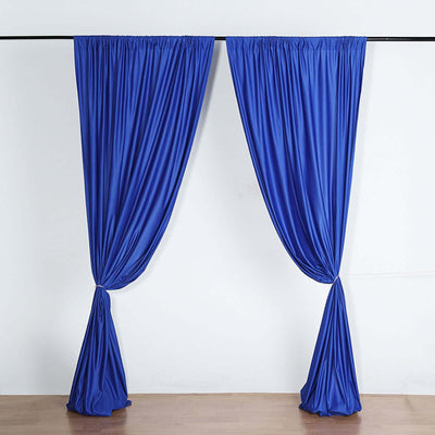Blue drapery curtains elegantly tied back against a plain backdrop.