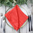 Red table napkin elegantly folded on a decorative plate with utensils. #whtbkgd