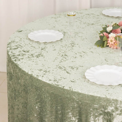 Soft sage green velvet tablecloth with scalloped plates and floral centerpiece