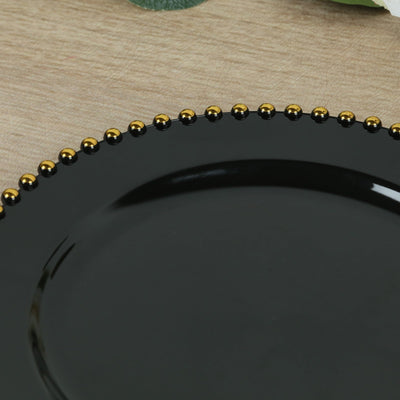 Black plate with gold beaded rim on wooden surface.