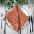 Rustic copper napkin elegantly displayed on a decorative plate. #whtbkgd