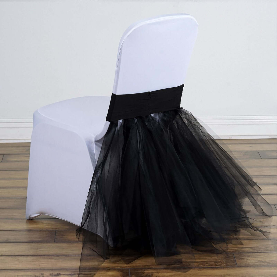 Elegant black tulle chair cover with a sleek white base.