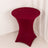 Round burgundy table with a fitted cover on a plain background.
