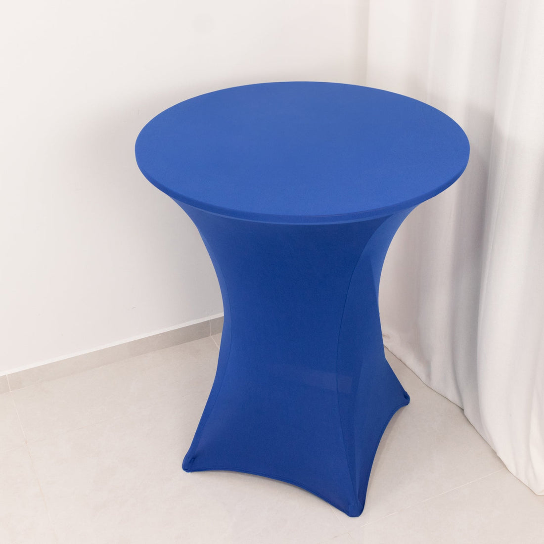 Blue cocktail table with a modern design on a plain backdrop.
