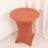 Round terracotta table with a sleek design against a white backdrop