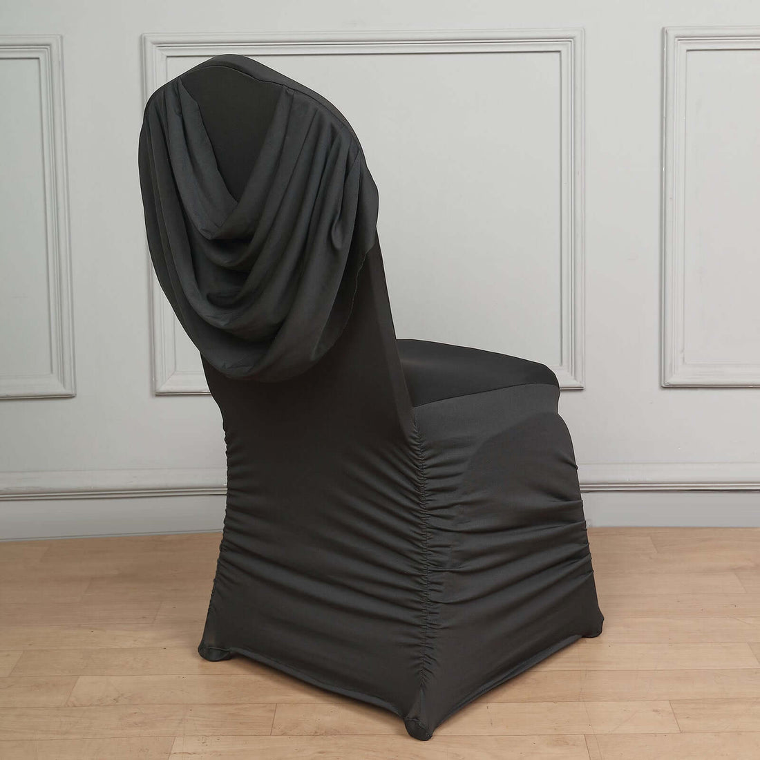 Black stretch chair cover with draped back for elegant decor.
