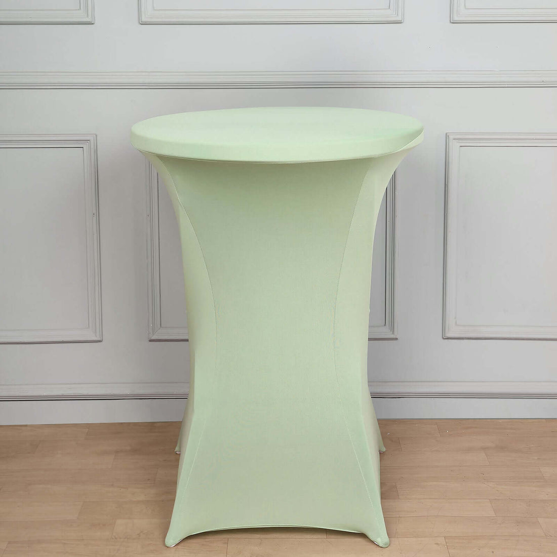 Green stretch table cover on a round table in a studio setting.