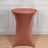 Round cocktail table with a fitted rust-colored stretch cover.