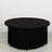 Black round table with pleated skirt, studio shot.