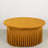 Round mustard yellow table with a pleated skirt