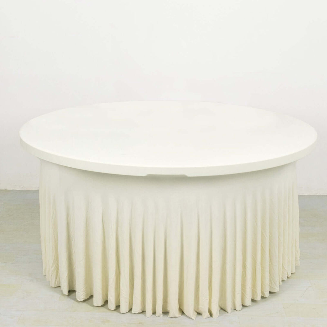 Round white table with a pleated cream tablecloth