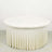 Round white table with a pleated cream tablecloth