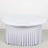 Round table with white draped skirt on plain background