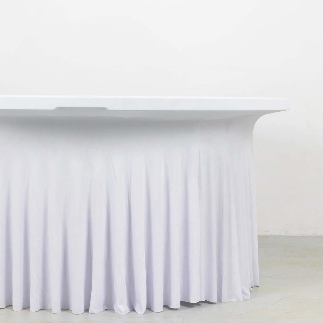 White table with a draped skirt, featuring a smooth surface and elegant design.