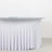 White table with a draped skirt, featuring a smooth surface and elegant design.