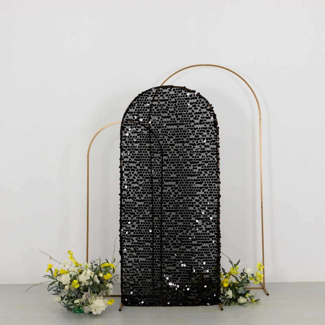 Black sequin backdrop with floral arrangements on the sides