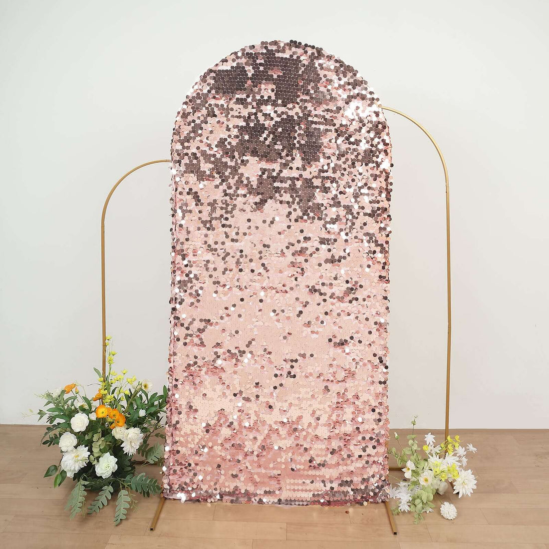 Pink sequin backdrop with gradient design and floral arrangements