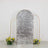 Silver sequin backdrop with floral arrangements on either side.