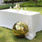 Gold reflective sphere beside a table set for dining outdoors.